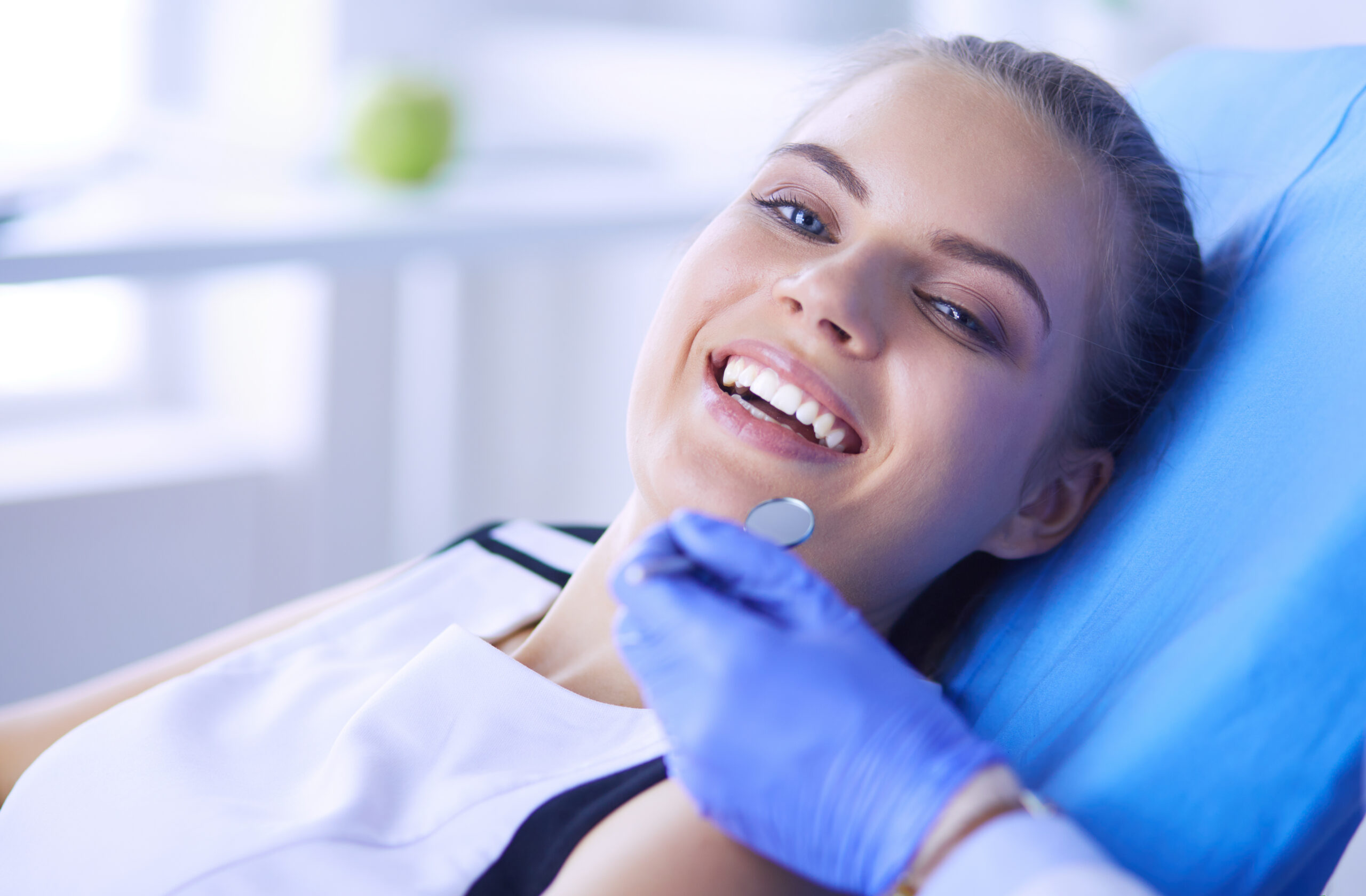 Young Female patient with open mouth examining dental inspection at